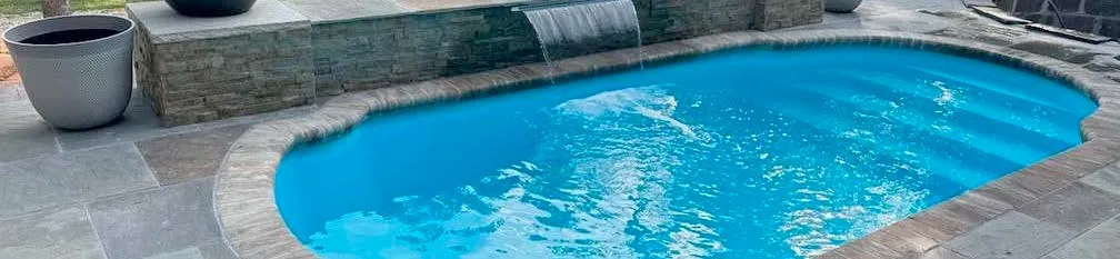 Freeform fiberglass pool with organic curves and waterfall in a Kansas City backyard